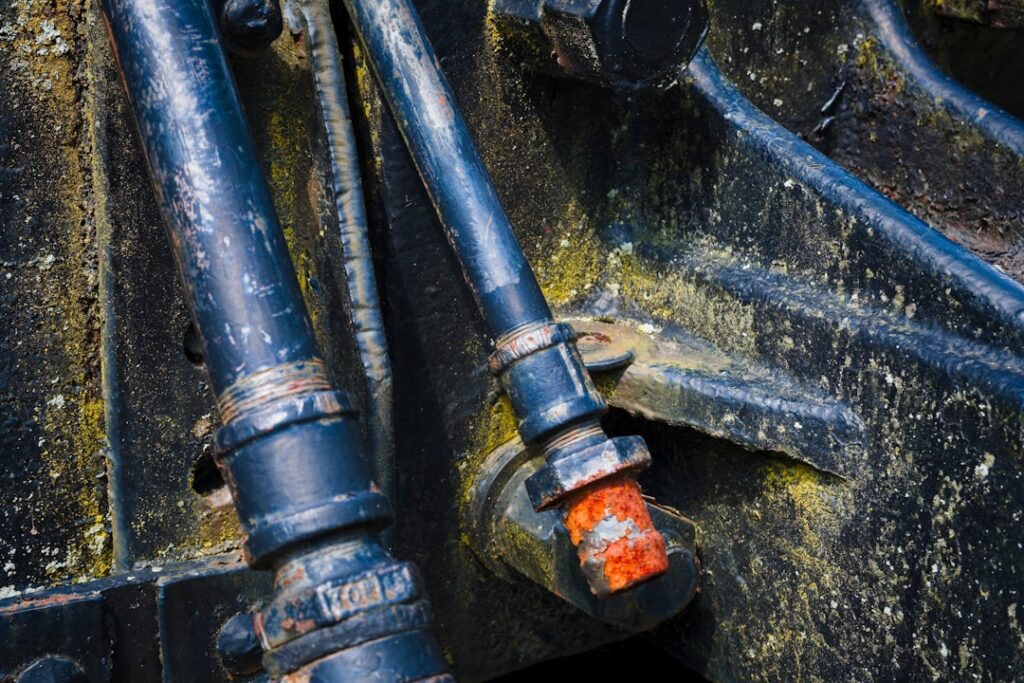 A close-up of assorted hydraulic fittings connected to metal hoses on a workbench.