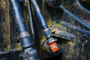 A close-up of assorted hydraulic fittings connected to metal hoses on a workbench.