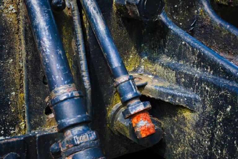 A close-up of assorted hydraulic fittings connected to metal hoses on a workbench.